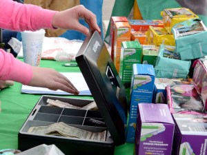 A girl puts money into a cash box.